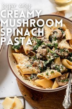 a bowl filled with pasta and mushrooms on top of a wooden cutting board next to cheese