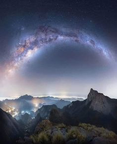 the night sky is filled with stars and clouds as seen from high up in the mountains