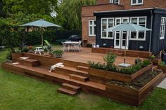 a wooden deck with steps leading up to it and an umbrella over the patio area