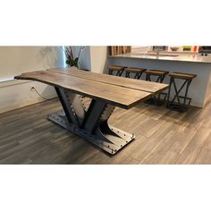 a wooden table sitting on top of a hard wood floor next to bar stools