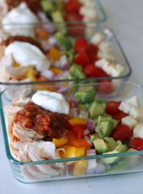 two glass containers filled with different types of food on top of a white tablecloth