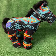 a small toy horse is on some green grass