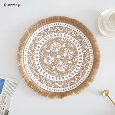 a white and brown plate sitting on top of a table next to a coffee cup