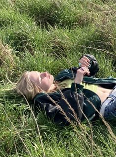 a woman laying on the ground in tall grass