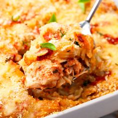 a casserole dish with meat and cheese being lifted from the casserole