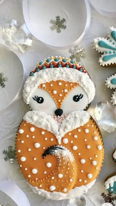 a decorated cookie with frosting and icing on it's face, surrounded by other cookies