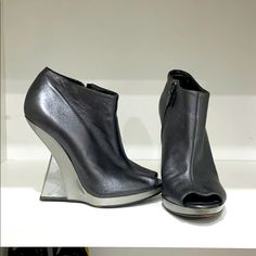 Metallic Gray Salvatore Ferragamo Open Toe Booties With A Pvc Heel Luxury Closed Toe Boots For Spring, Designer Leather Boots For Spring, Formal Open Toe Leather Boots, Designer Closed Toe Boots With Reinforced Heel, Designer Ankle-high Heels With Leather Sole, Designer Ankle-high Leather Heels, Designer Ankle-high Spring Boots, Luxury Open Toe Leather Boots, Luxury Leather Open Toe Boots