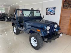 a blue jeep is parked in a showroom