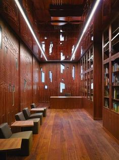 an empty library with benches and bookshelves lined up against the wall, along with wooden flooring