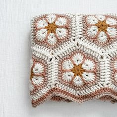 a crocheted square with flowers on it sitting on top of a white surface