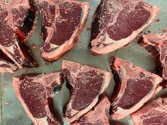 several pieces of raw meat sitting on top of a table next to some other food