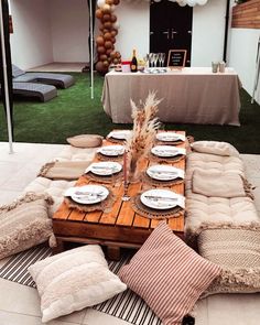 a table set up with pillows and plates