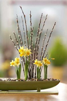 a vase filled with yellow flowers sitting on top of a table