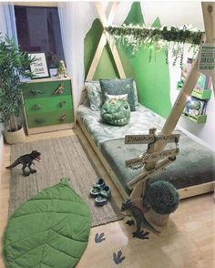 a bedroom decorated in green and white with dinosaur decorations