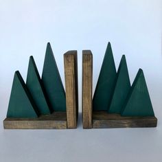 two wooden bookends with green mountain tops on each one and wood blocks in the middle