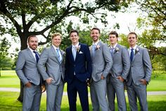 a group of men in suits standing next to each other on a lush green field