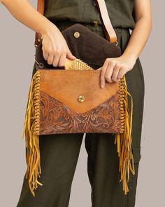 Introducing our latest Artisan Tooled Leather Fringe Bag, a stunning handmade leather clutch for women. We’ve used premium buffalo leather and added a suede leather tassel on the side to give it that rich, luxurious look. Plus, it comes with a detachable belt so you can carry it as a crossbody. Product Details: Material: Cowhide, ,Genuine LeatherDimensions: Height 22cm x Length 28cm x Width 2cm Height 8.6" x Length 11" X Width 0.7" Zipper: YKK Premium Zipper Inner Lining: Cotton (Primary Fabric) Interior: High-quality cloth lining for a polished lookOne zipper pocket for money and cardsOne open pocket for your small wallet or other essentialsDiscover the exquisite craftsmanship of our Handmade Buffalo Leather Sling Bag, designed for women who want style and functionality. Each bag is hand- Leather Pouch Clutch With Leather Handles, Leather Clutch With Leather Handles, Hand Tooled Leather Pouch Wallet, Hand Tooled Travel Clutch, Hand Tooled Leather Clutch, Brown Hand Tooled Clutch Bag, Hand Tooled Leather Rectangular Clutch, Brown Hand Tooled Clutch Shoulder Bag, Everyday Hand-tooled Leather Pouch