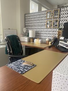 an office with a desk, chair and laptop on top of the desk is decorated with black and white chevron wallpaper