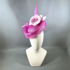 Sculptural sinamay strawcloth in vibrant orchid. Circled in delicate matching veiling. Accented in a handmade pastel, pure silk, rose with ombre enter intensifying to a matching orchid shade. Elastic and comb attachment for easy, comfortable wear. Lifted Millinery headwear is constructed with time honored techniques and fine craftsmanship. All hats are meticulously blocked and sewn by hand without the use of adhesives to attach trims. This ensures a long lasting hat with the ability to be retrim Pink Fascinator For Kentucky Derby Ceremony, Pink Headpiece For Kentucky Derby Ceremony, Elegant Pink Headpieces For Ceremonies, Pink Mini Hats For Kentucky Derby Ceremony, Pink Fascinator For Royal Ascot Ceremony, Pink Sinamay Fascinator For Kentucky Derby, Pink Summer Fascinator For Ceremony, Adjustable Pink Hat For Ceremony, Pink Adjustable Hat For Ceremony