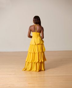 This tie up halter neck dress features layers design ruffled with zip back closure. Model wearing size smallFits true to size for most Yellow Party Dress With Ruffled Straps, Yellow Dresses With Ruffled Straps For Party, Fitted Yellow Maxi Dress With Tie Back, Fitted Yellow Dresses With Ruffled Skirt, Yellow Dresses With Ruffles And Ruffled Straps, Yellow Dress With Ruffled Straps And Details, Spring Fitted Tiered Halter Dress, Flowy Yellow Dress With Ruffle Hem, Chic Yellow Dresses With Ruffle Hem