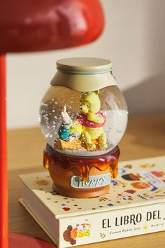 there is a snow globe with winnie the pooh in it on top of a book