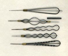 four different types of knitting needles on a white surface