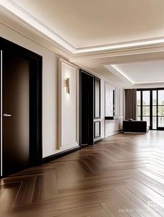 an empty room with wooden floors and black doors