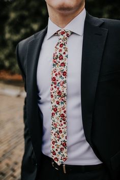 a man wearing a suit and tie with flowers on it