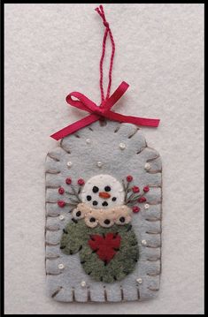 a snowman ornament hanging from a red ribbon