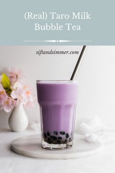 a purple drink in a glass with black dots on it and the words real taro milk bubble tea