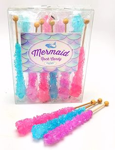 three small candy lollipops in a clear box with the words mermaid on them