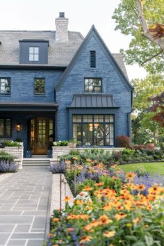 a blue house with lots of flowers in front