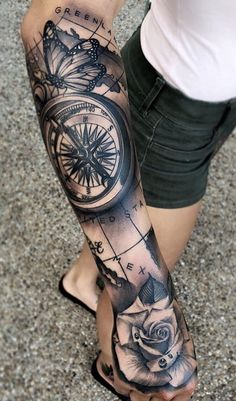 a woman's leg with a compass and rose tattoo on it