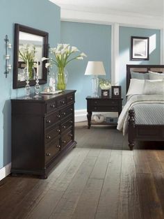 a bedroom with blue walls and wooden floors