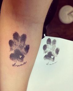 a person with a tattoo on their arm that has a dog's paw print