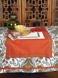 a table topped with a bowl and plate next to a vase on top of a table