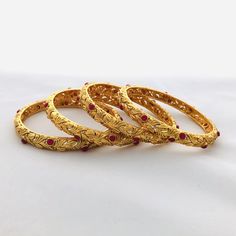 Kundan Ruby Golden Bangles,Golden Bangles,Kundan Meenakari bangles,Kundan Bangles,Kundan wedding jewelry,Kundan bangles@AryaFashions in 2.4 Traditional Bollywood bracelet bangle set of 4 with Kundan, Stones, Meenakari and beads work. * Beautiful designer Gold tone Kundan bangles * The base metal color is Gold tone studded with white kundan and colorful semi precious stones on it. * The bangles are available in 2.4 size. All our jewelry pictures are taken in natural light with no filters and enha Metal Round Bangle For Wedding, Metal Bangle For Weddings, Red Elegant Bracelets For Wedding, Elegant Red Bracelets For Wedding, Indian Wedding Bangles, Meenakari Bangles, Golden Bangles, Jewelry Pictures, Wedding Bangles