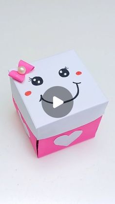 a pink and white box with a face on it