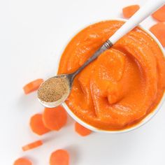 a spoon in a small bowl filled with carrots