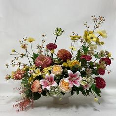 a vase filled with lots of different colored flowers