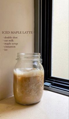 an iced maple latte in a jar next to a window