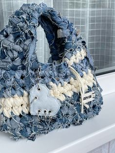 a bag made out of old jeans sitting on top of a window sill