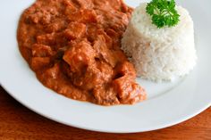 a white plate topped with meat and rice