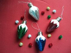 three christmas ornaments sitting on top of a red table