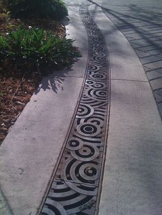 an artisticly designed sidewalk on the side of a street