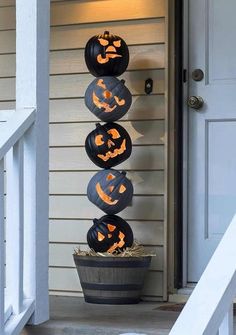 three pumpkins are stacked on top of each other in front of a door way