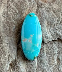 a turquoise stone sitting on top of a rock