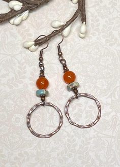 These boho everyday earrings, perfect not only for fall, but anytime of year, were created using orange dyed Quartzite gemstone beads, Serpentine Jasper heishi beads in light turquoise with splashes of orange and beige, small daisy spacer beads, and antique copper hammered connector hoops. Total length of earrings, including the ear wire, is approximately 2-1/2".  The hoops measure slightly less than 1" x 1". For matching bracelet, click on the link below: https://www.etsy.com/listing/1775405734/boho-gemstone-layered-bracelet-bohemian?click_key=dd7cc051989c2a01f33517f997db305a15f4ae31%3A1775405734&click_sum=2e4d6686&ref=shop_home_active_1&frs=1&sts=1 Thank you for shopping with The Lucie Collection! Bohemian Wire Wrapped Hoop Earrings For Everyday, Bohemian Hoop Earrings With Natural Stones For Jewelry Making, Bohemian Copper Hoop Earrings As Gift, Everyday Bohemian Copper Jewelry, Rust Color Dangle Earrings With Ear Wire, Rust Dangle Earrings With Ear Wire, Bohemian Rust Earrings With Ear Wire, Rustic Handmade Hoop Earrings, Nickel Free Orange Earrings For Everyday