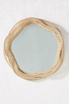 a mirror that is on the wall next to a white wall with a rope around it