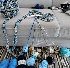 several skeins of yarn are on the floor next to a couch